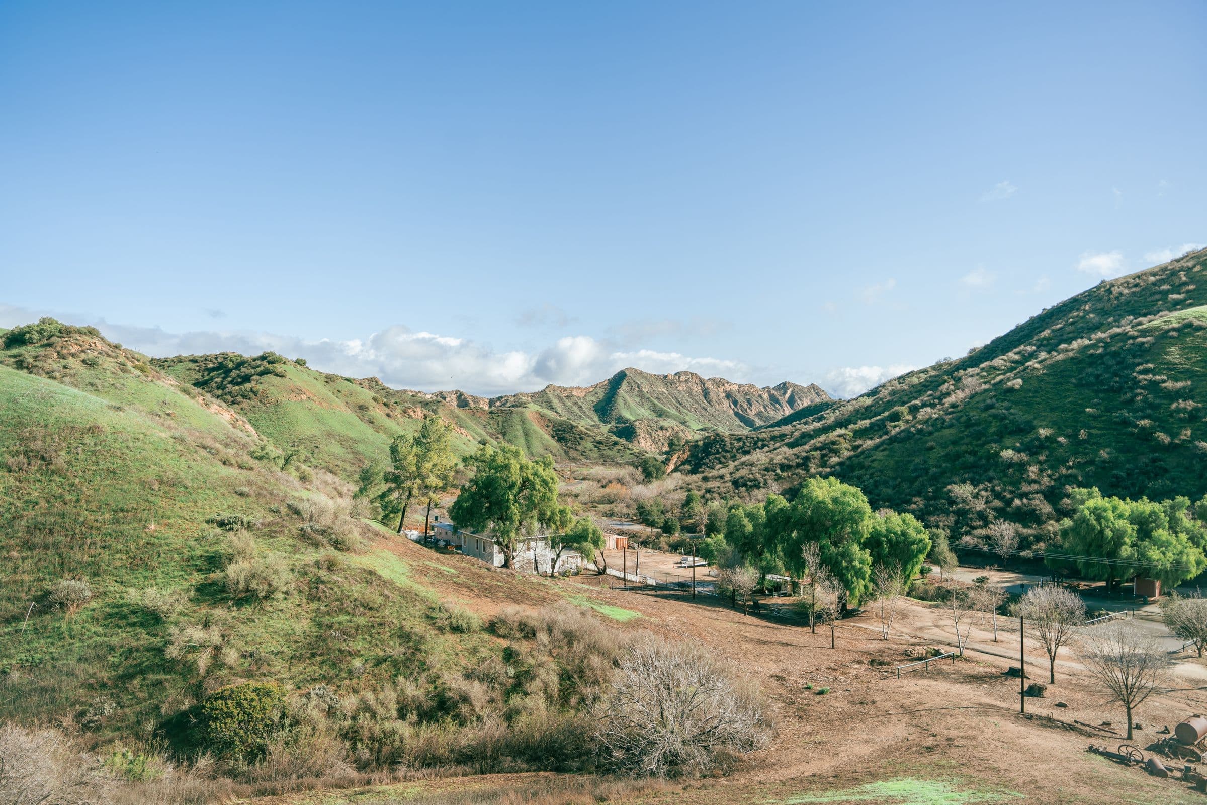 Breathtaking view of a rustic valley with lush green hills under a clear blue sky, the kind of North County setting our movers work in around Fallbrook, CA